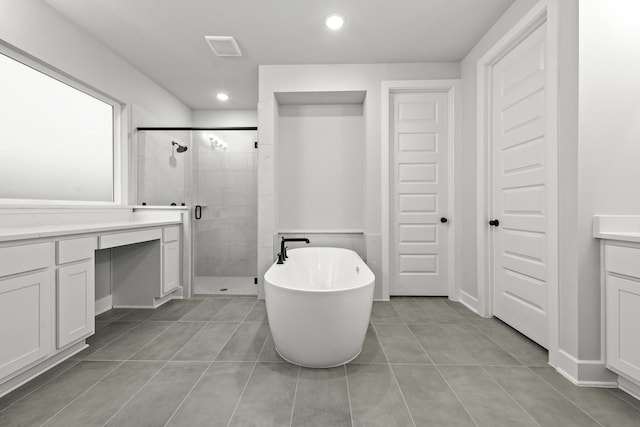 full bathroom with visible vents, vanity, a stall shower, a freestanding bath, and tile patterned flooring