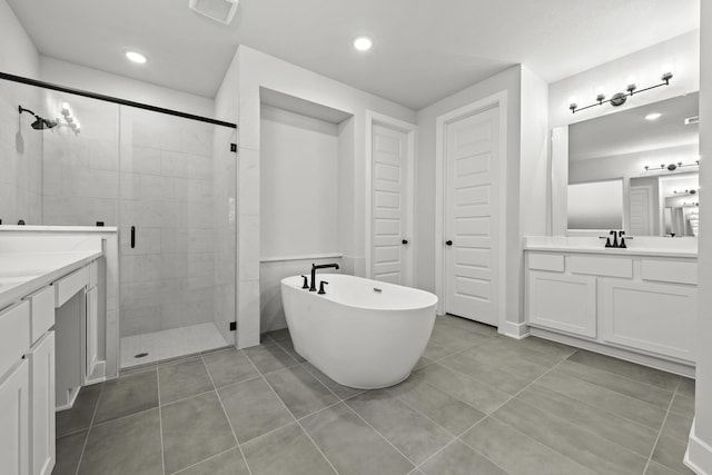bathroom featuring visible vents, tile patterned floors, two vanities, a stall shower, and a freestanding bath