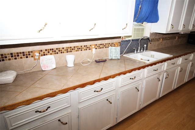 kitchen with tasteful backsplash, sink, tile countertops, and white cabinets