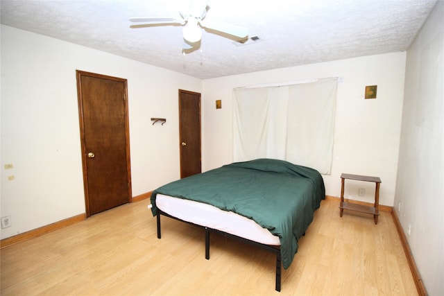 bedroom featuring wood-type flooring, a textured ceiling, and ceiling fan