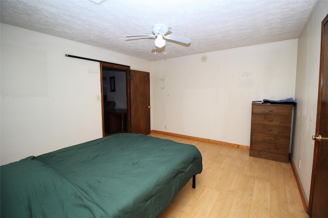 bedroom featuring a textured ceiling, light hardwood / wood-style floors, and ceiling fan