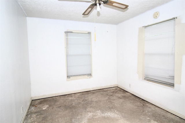 empty room featuring ceiling fan, concrete flooring, and a textured ceiling