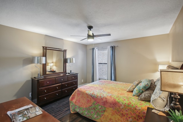 bedroom with ceiling fan, a textured ceiling, and dark hardwood / wood-style flooring