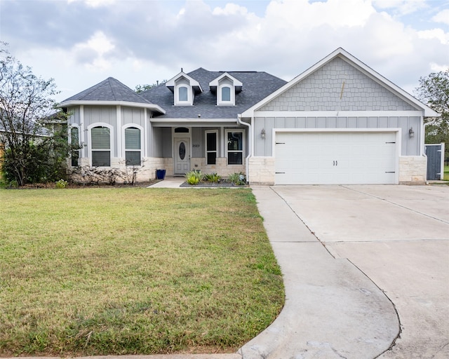 view of front of home featuring a garage, a front lawn, and covered porch