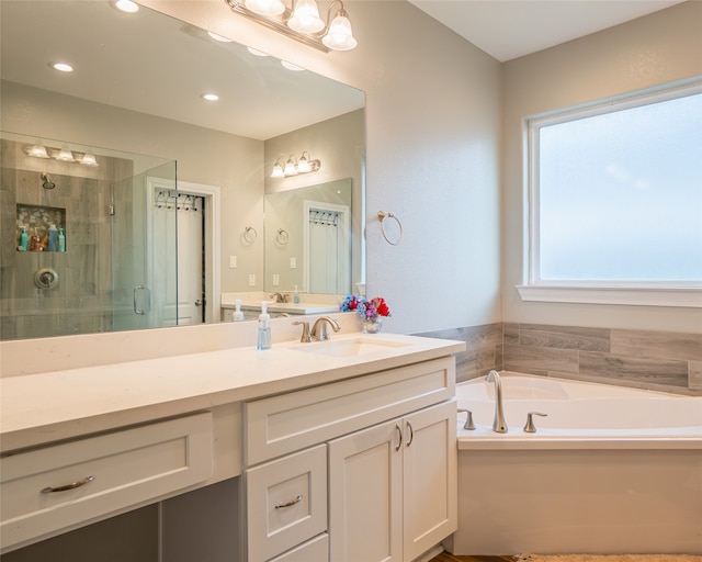 bathroom featuring vanity and shower with separate bathtub