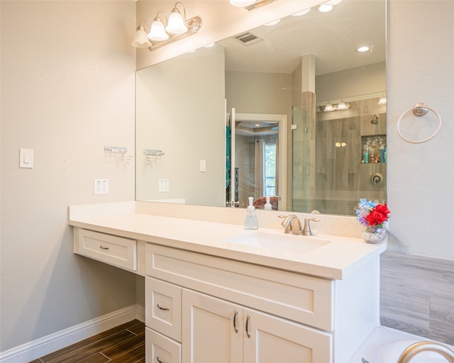 bathroom with hardwood / wood-style flooring, vanity, and an enclosed shower