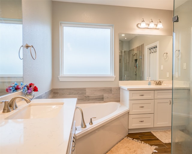 bathroom with wood-type flooring, vanity, and separate shower and tub