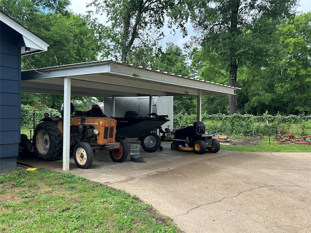 view of vehicle parking featuring a detached carport and fence