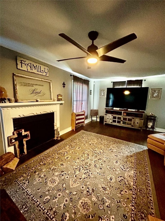 living room featuring a fireplace with flush hearth, a textured ceiling, a ceiling fan, and wood finished floors