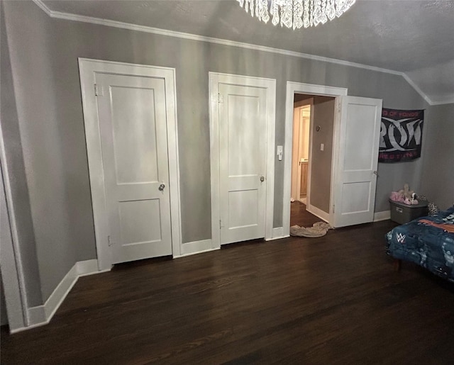 bedroom with baseboards, an inviting chandelier, ornamental molding, and wood finished floors