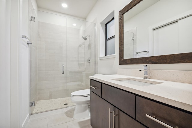 bathroom featuring tile patterned flooring, vanity, toilet, and walk in shower