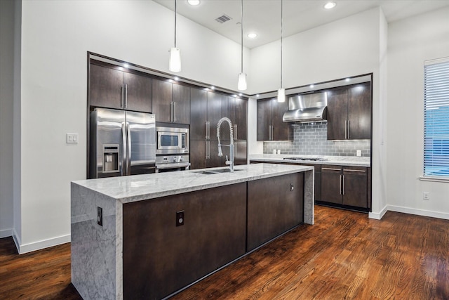 kitchen featuring appliances with stainless steel finishes, dark hardwood / wood-style flooring, hanging light fixtures, and sink