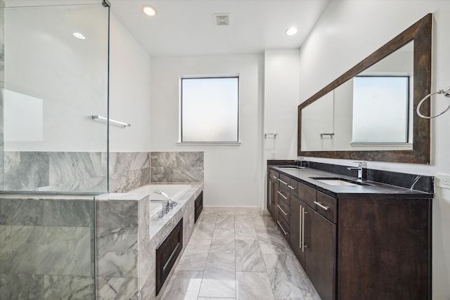 bathroom with vanity and tiled bath