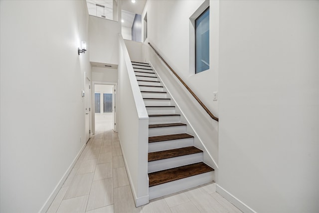 staircase featuring a towering ceiling