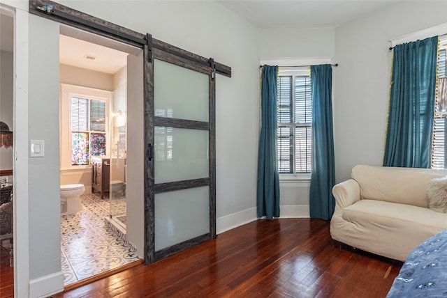 sitting room with a barn door and hardwood / wood-style floors