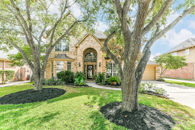 english style home with a front yard and a garage