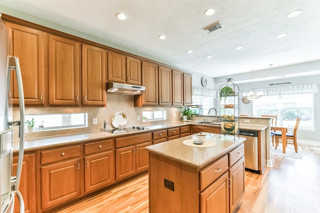 kitchen with a kitchen island, stainless steel dishwasher, light wood-type flooring, black electric stovetop, and sink