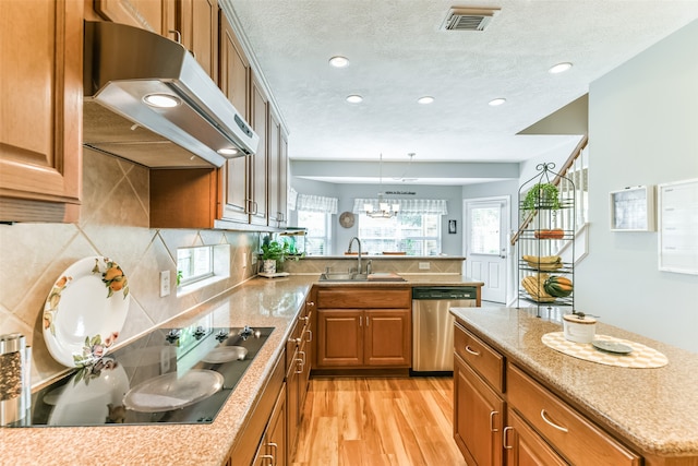 kitchen featuring an inviting chandelier, light wood-type flooring, dishwasher, range hood, and sink