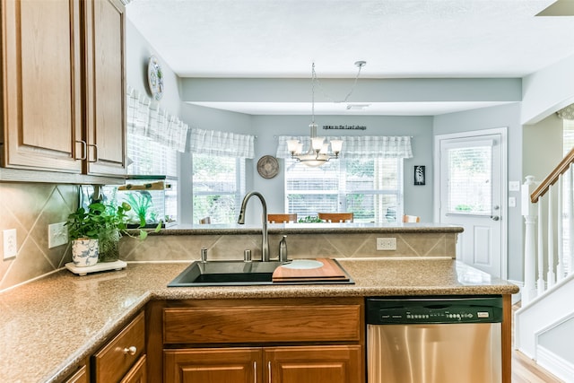 kitchen featuring sink, backsplash, decorative light fixtures, stainless steel dishwasher, and a chandelier