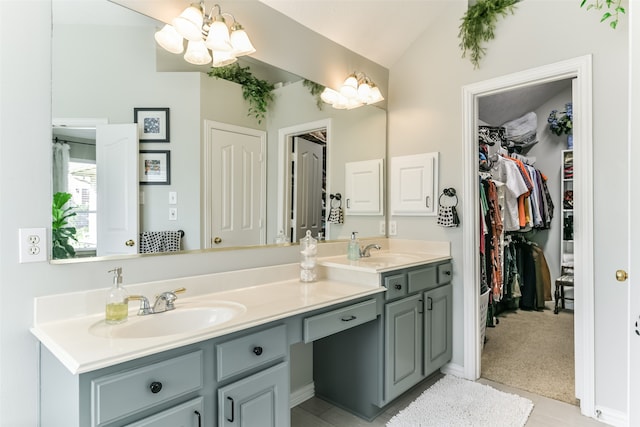 bathroom featuring vanity, an inviting chandelier, and vaulted ceiling