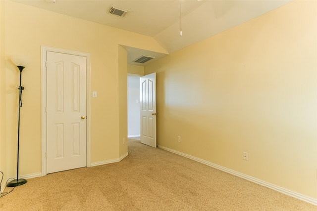 unfurnished bedroom featuring vaulted ceiling and light colored carpet