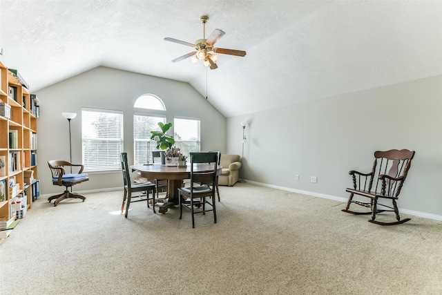 carpeted dining room with lofted ceiling, a textured ceiling, and ceiling fan