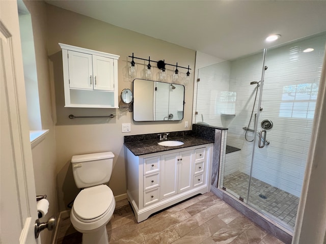 bathroom featuring vanity, toilet, and an enclosed shower