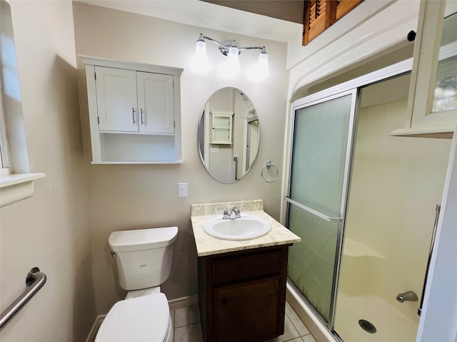 bathroom with a shower with door, vanity, toilet, and tile patterned floors