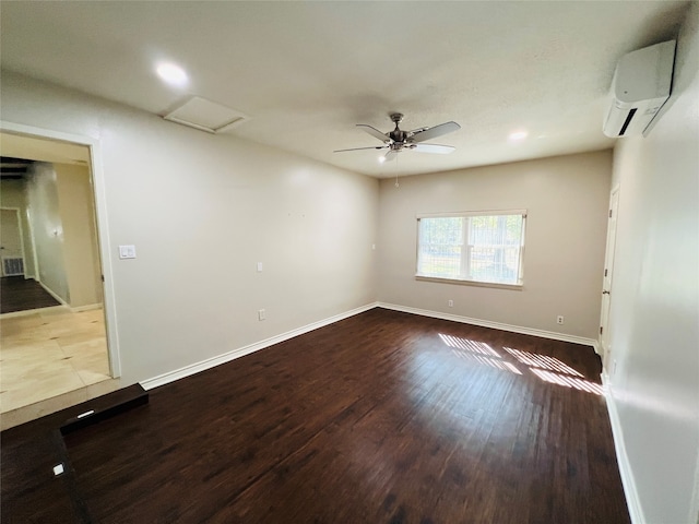 spare room featuring a wall unit AC, light wood-type flooring, and ceiling fan