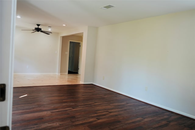 spare room featuring dark wood-type flooring and ceiling fan