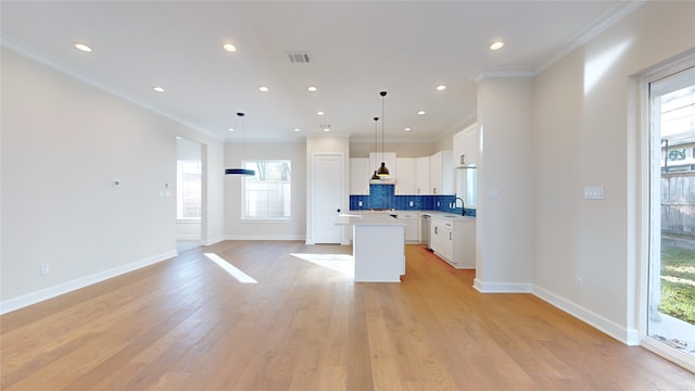 kitchen featuring a center island, light hardwood / wood-style floors, decorative light fixtures, decorative backsplash, and white cabinets