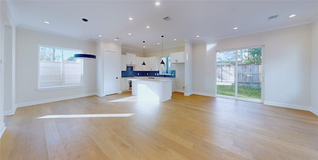 kitchen featuring crown molding, white cabinets, pendant lighting, and a kitchen island