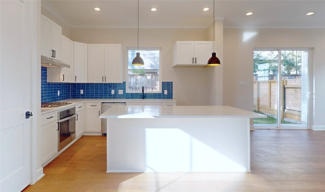 kitchen featuring white cabinets, appliances with stainless steel finishes, a center island, and sink