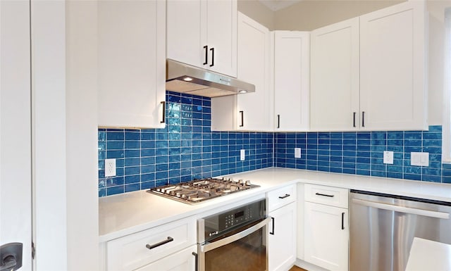 kitchen with white cabinets, appliances with stainless steel finishes, and tasteful backsplash