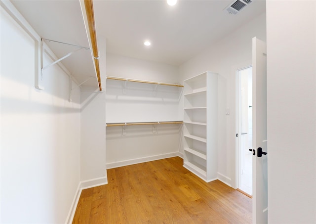 walk in closet with hardwood / wood-style floors