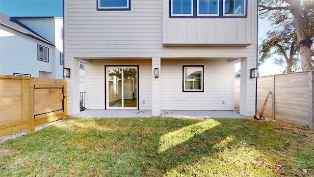 back of property featuring a patio area and a lawn