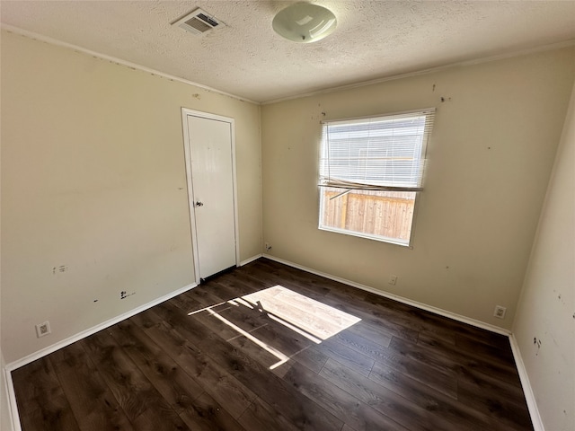 empty room featuring a textured ceiling and dark hardwood / wood-style flooring