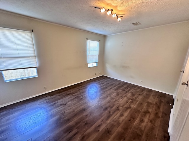 empty room featuring a textured ceiling and dark hardwood / wood-style flooring