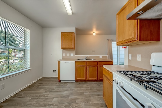 kitchen featuring sink, light hardwood / wood-style flooring, white appliances, and extractor fan