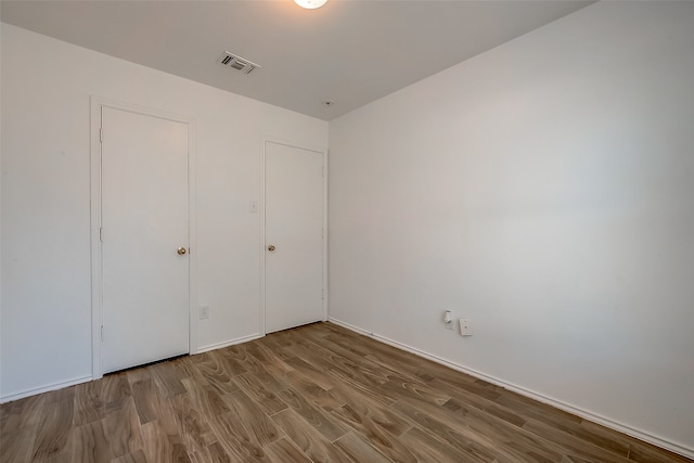 unfurnished bedroom featuring a closet and hardwood / wood-style flooring