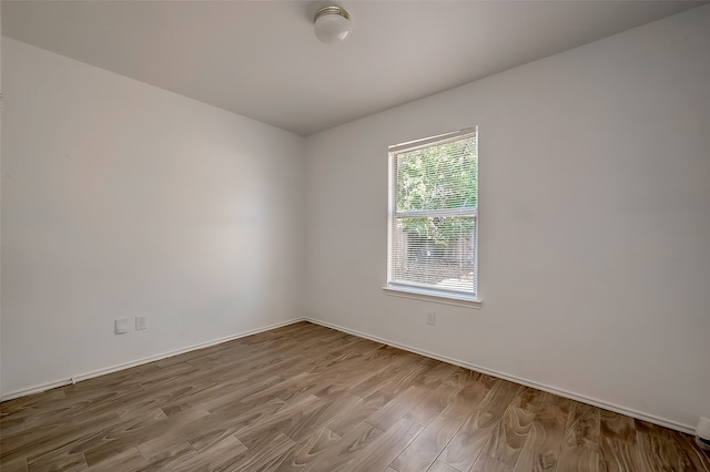 unfurnished room with hardwood / wood-style flooring