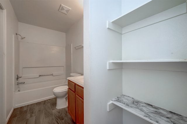 full bathroom featuring toilet, vanity, wood-type flooring, and washtub / shower combination