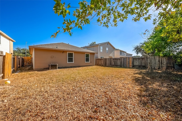 rear view of house featuring a yard and central air condition unit