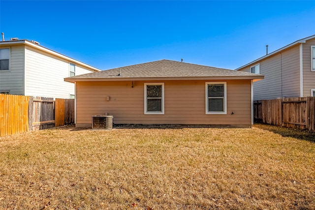 back of house featuring central AC and a lawn