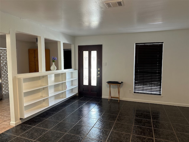 foyer entrance with dark tile patterned flooring