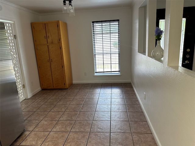 spare room with crown molding and light tile patterned floors