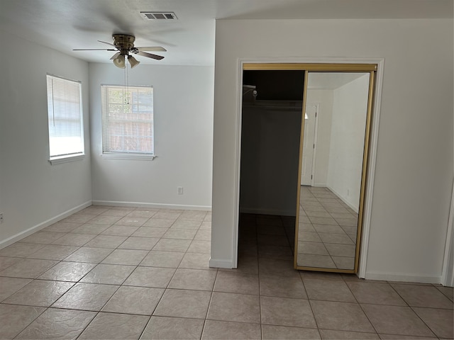 unfurnished bedroom with a closet, light tile patterned floors, and ceiling fan