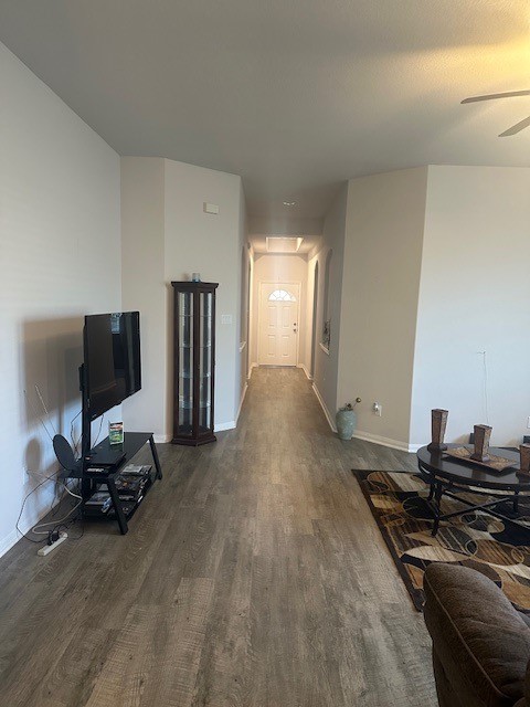 living room with ceiling fan and dark hardwood / wood-style flooring