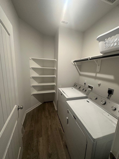 clothes washing area with washer and dryer and dark hardwood / wood-style floors