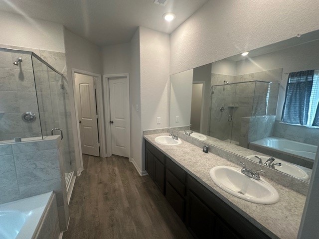 bathroom featuring vanity, hardwood / wood-style floors, and plus walk in shower